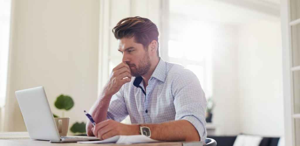 Man looking worriedly at laptop